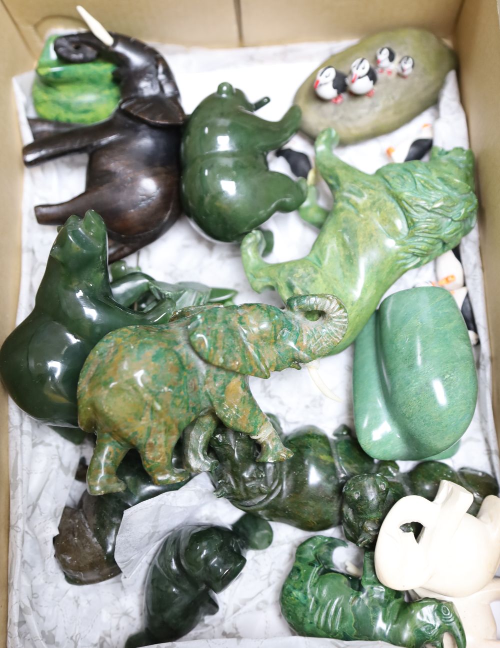 Fourteen various jadeite and hardstone carvings, a puffin group etc. lion length 11cm